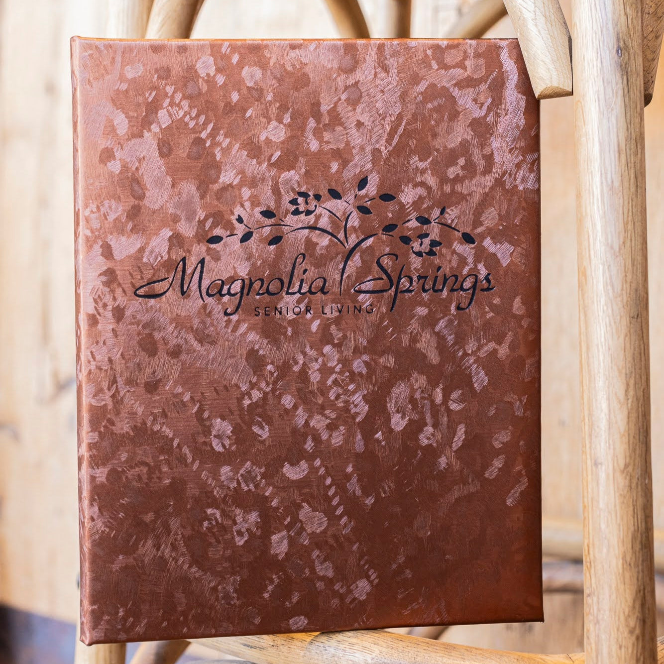brushed metallic carded menu with magnolia springs senior living logo in black foil stamp