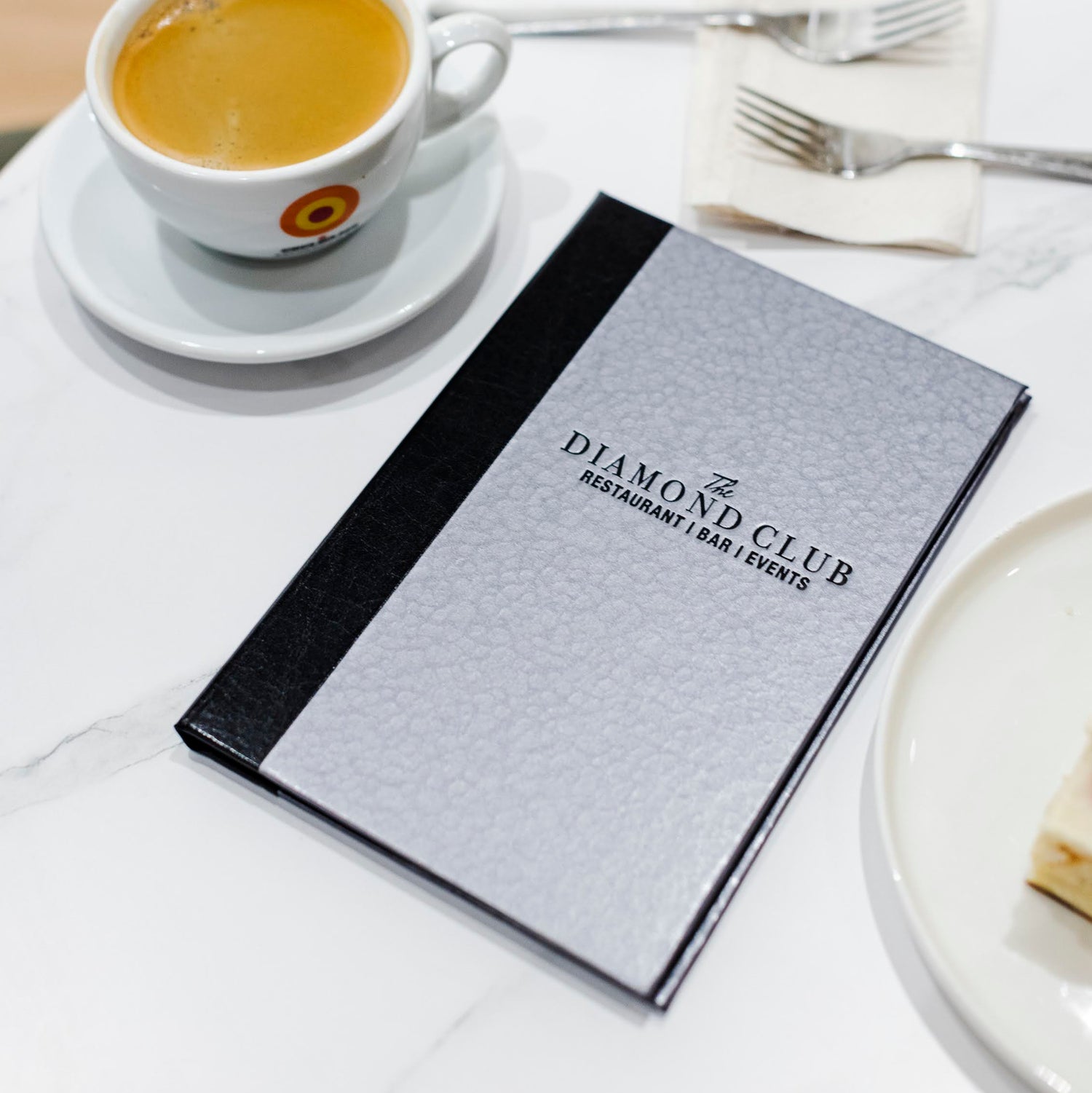 metro iron silver menu cover with black foil stamped logo restaurant bar and events